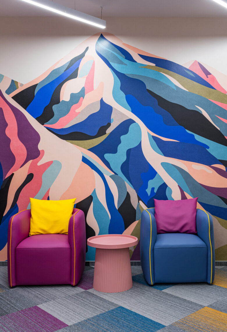 Waiting seats in front of an illustrated mountain landscape.