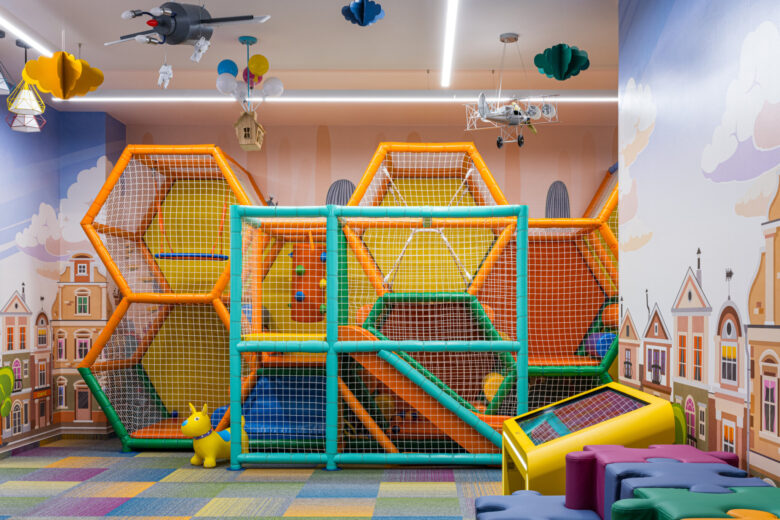 Multilevel play structure with green and yellow framing, passages and a slide.